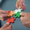Group of business people assembling jigsaw puzzle and represent team support and help concept
